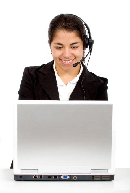 Customer Service Girl At Her Desk On A Laptop Computer Smiling