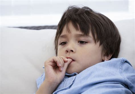 Portrait Of Kid Biting His Finger Nails While Looking At Something