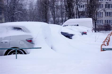 Heavily Snowed Cars In The Parking Lot Snowfall In The City Stock Photo