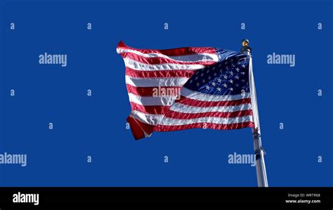 American Flag Waving Against A Clear Blue Sky Stock Photo Alamy