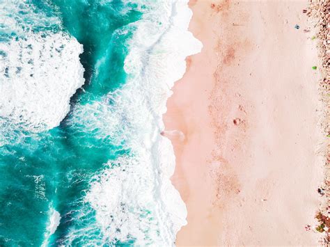 Drone Aerial View Of The Ocean Washing On The Sand Beach In California