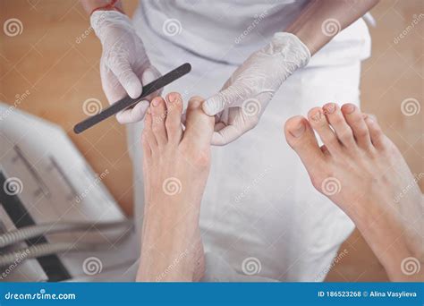 Pedicurist Doing Professional Medical Pedicure Procedure In Beauty Salon Using Nail File Foot