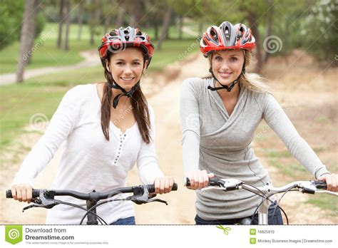 Two Female Friends Riding Bikes In Park Stock Photo Image Of Ride
