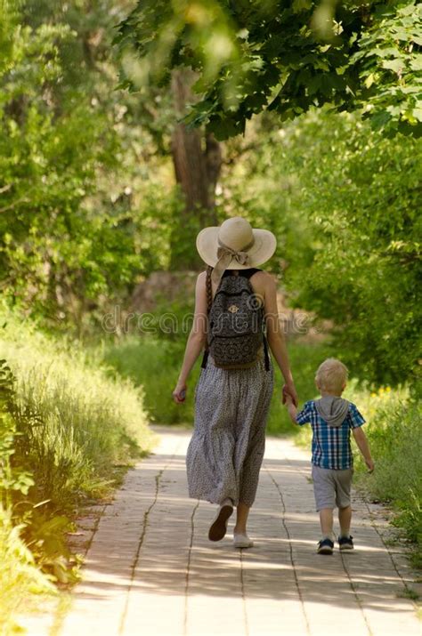 Mom And Son Walking Along The Road In The Park Back View Stock Image