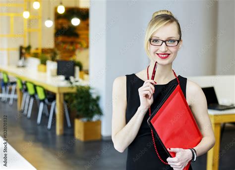 Cheerful Pretty Girl Assistant Holds In Hands A Pen And Folders In An Office Stock Foto Adobe