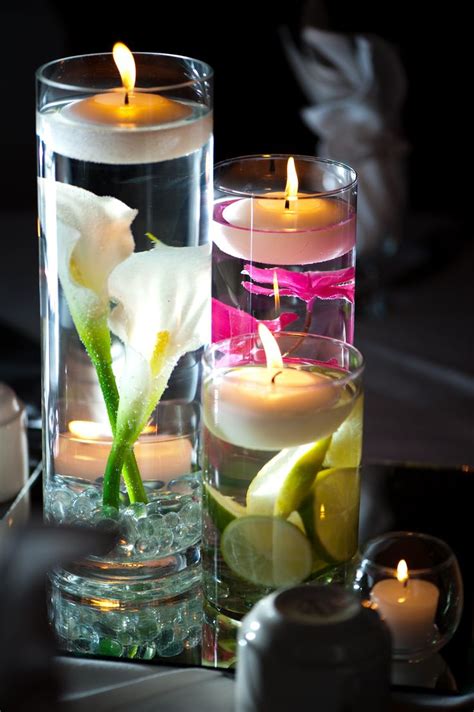 Glass Vases Filled With Submerged Calla Lilies And Other Bright Flowers Were Topped With Floa