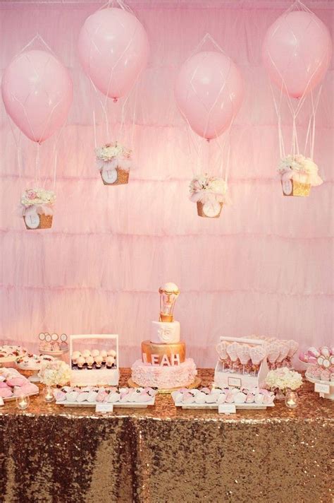A Table Topped With Lots Of Cakes And Desserts Next To Pink Balloons On