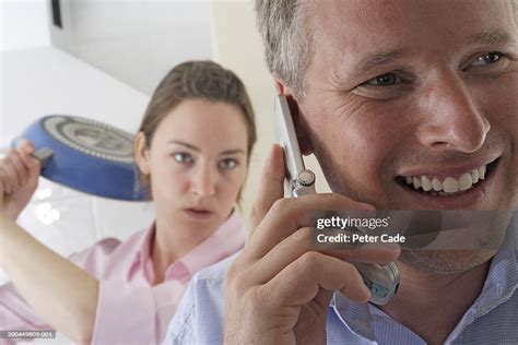 Woman With Frying Pan About To Hit Man Laughing On Mobile Phone High