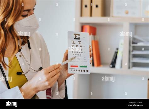 Female Ophthalmologist Pointing At Eye Chart In Clinic Stock Photo Alamy