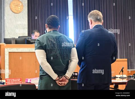 Cesar Santana in court wearing a jailhouse uniform and handcuffs. Cesar