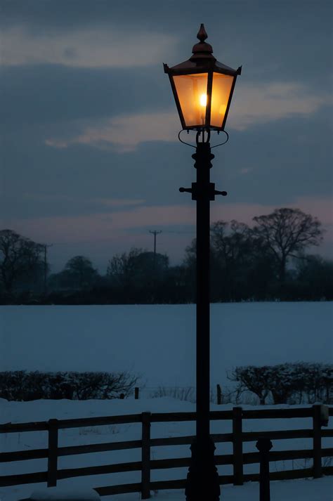 A Traditional Victorian Lamp Post Glowing On A Winters Evening Street