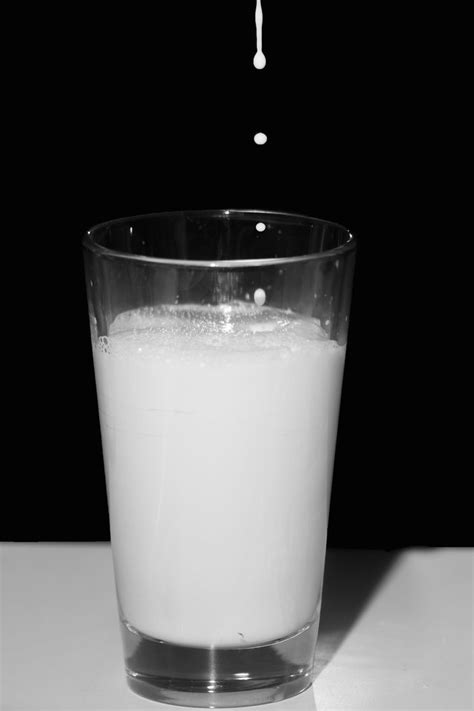 A Glass Filled With Milk Sitting On Top Of A Table