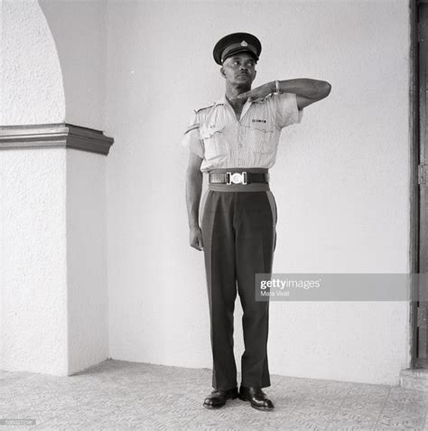 A Jamaican Police Officer Stands Guard Wearing An Official Uniform Police Officer How To