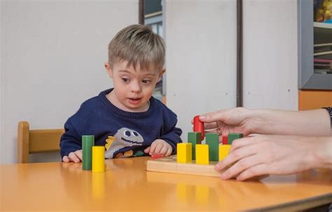 Premium Photo Boy With Living Down Syndrome Enjoying Playtime With
