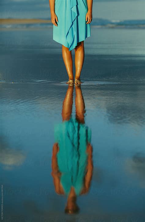 Woman Standing In The Sea Shore Reflected On Water Del Colaborador De