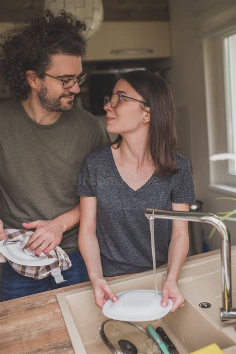 Couple In Love Doing The Washing Up After Lunch Together Stock Image