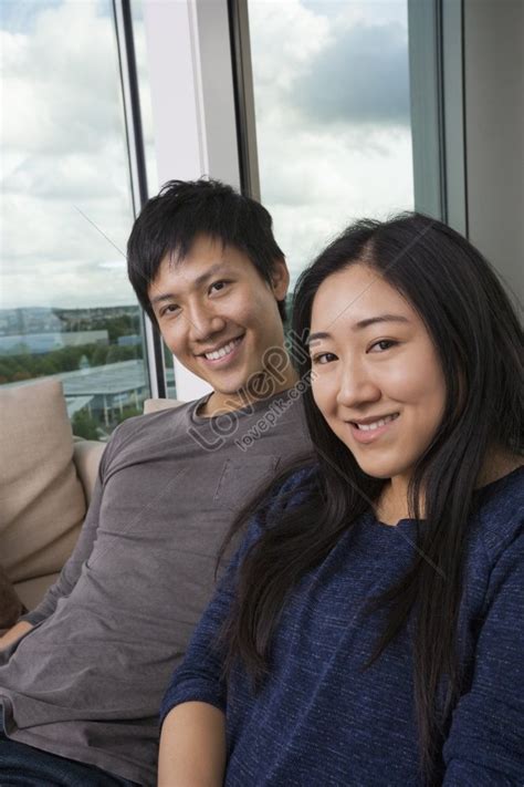 Portrait Of Asian Couple Sitting On Sofa At Home Smiling Happily Picture And Hd Photos Free