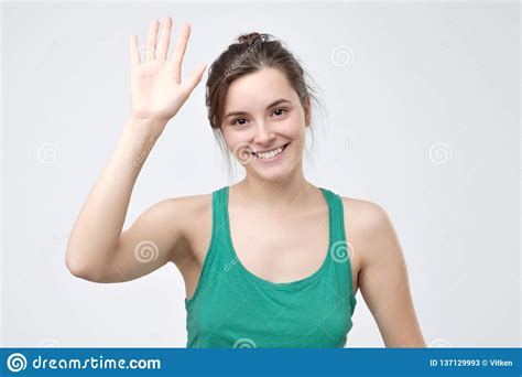 Pretty Student Girl Saying Hello Smiling Joyfully And Friendly Waving
