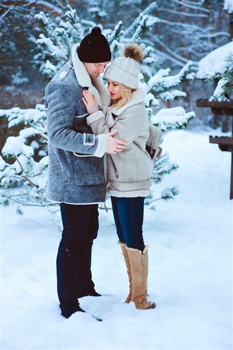 Winter Portrait Of Happy Romantic Couple Warm Up Each Other On The Walk In Snowy Forest Stock