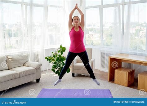 Young Fitness Woman Doing Jumping Jacks Or Star Jump Exercise At Home