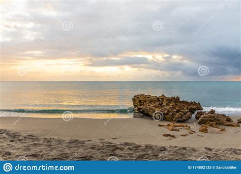 Daybreak Over Calm Seas And A Rocky Beach Stock Image Image Of