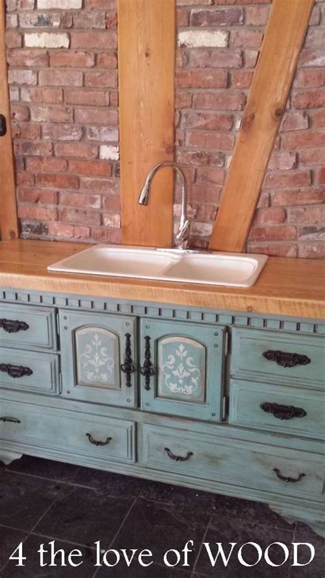 An Old Dresser Is Painted Blue With White Flowers And Has A Sink In The