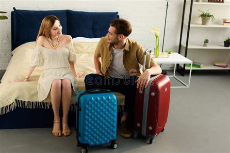 Happy Couple With Suitcases Ready For Vacation Sitting On Bed Stock Image Image Of Happy