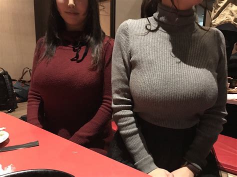 Two Women Standing Next To Each Other In Front Of A Table With Food On It