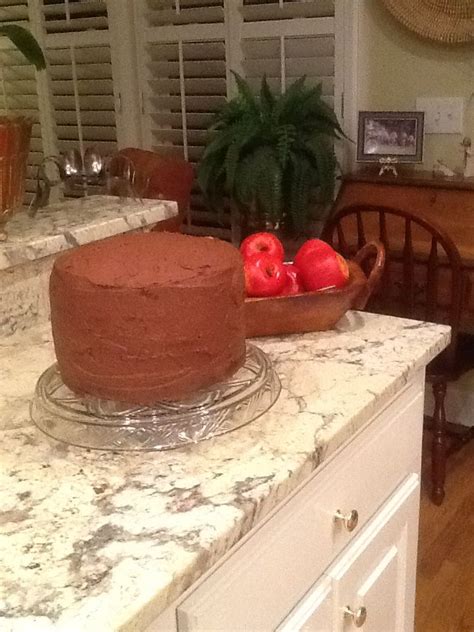 A Cake Sitting On Top Of A Kitchen Counter Next To A Bowl Of Tomatoes
