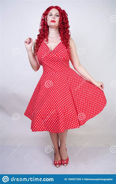 plus kvinna för rött hår för format lockig med den curvy kroppen som bär den nätta klänningen