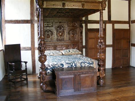 A Bed Sitting In The Middle Of A Room With Wooden Floors And Furniture