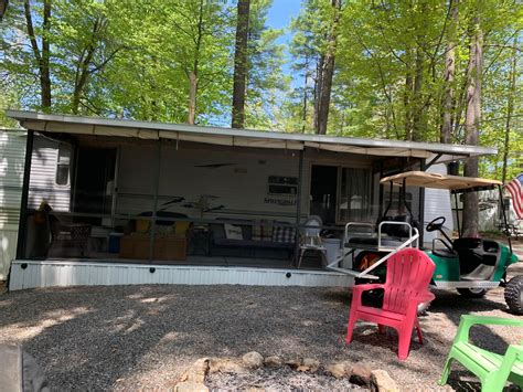 Camper with screen porch and golfcart on seasonal site in gated