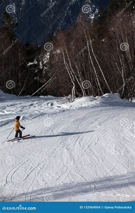 Skier Descent On Snowy Ski Slope In Forest At Sun Winter Day Editorial