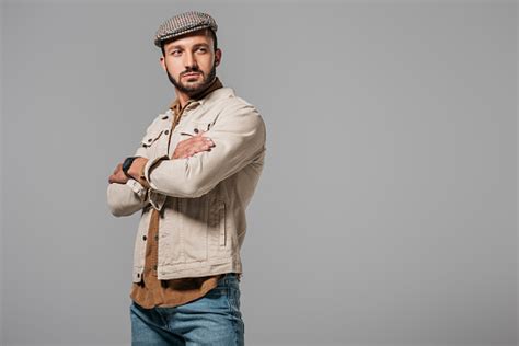 Handsome Man In Autumn Jacket And Tweed Cap Posing With Crossed Arms
