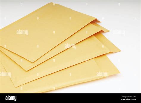 Pile Of Blank Manila Envelopes Against A White Background Stock Photo