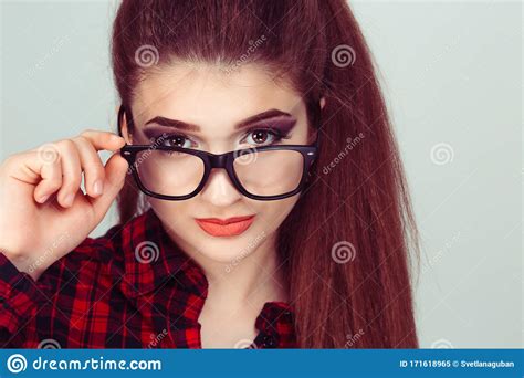 confused skeptical woman thinking looking at you with disapproval pulling down her eye glasses