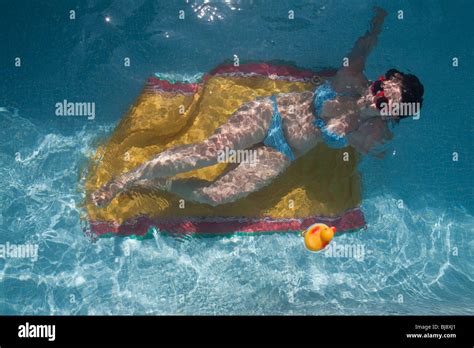 Woman Sunbathing At The Bottom Of A Swimming Pool Stock Photo Alamy