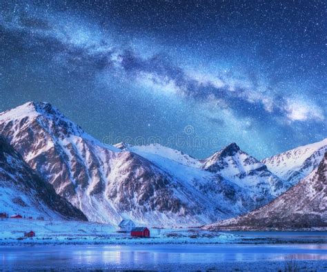 Milky Way Above Houses And Snow Covered Mountains In Winter Stock Photo
