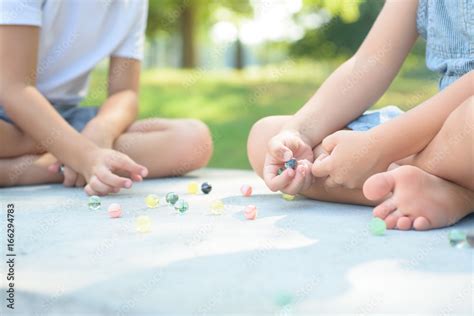 Kids Playing Marbles Game Outside Stock Photo Adobe Stock