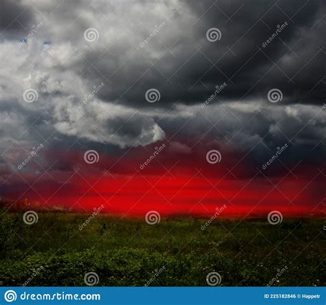 Dramatic Stormy Clouds And Red Sunset Sky Over Green Field Stock Photo