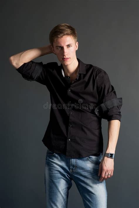 Young Man In Black Shirt And Jacket On Dark Background Stock Photo