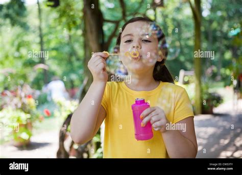 Girl Blowing Bubbles In Garden Stock Photo Alamy