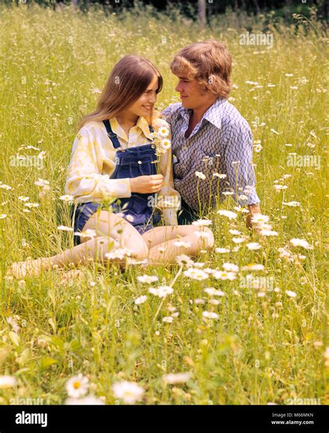 1970s Romantic Teenage Couple Sitting In A Field Of Daisies Kj6265