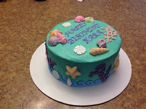 A Birthday Cake Decorated With Seashells And Starfish