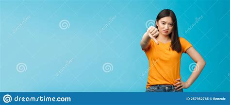 Disappointed And Unsatisfied Cute Asian Girl Grimacing Showing Thumb Down No Dislike Sign