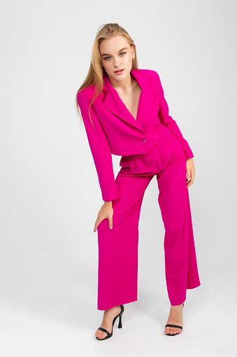 Longhaired Blonde Woman In A Pink Suit Against A White Background Stock