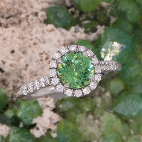 A Ring With A Green Stone Surrounded By Leaves