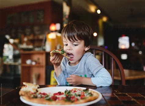 Boy Eats Pizza In Pizzeria By Stocksy Contributor Maria Manco Stocksy