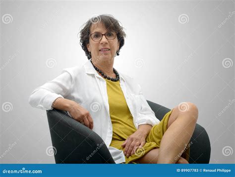 Mulher Madura Atrativa Que Senta Se Em Uma Cadeira Preta Imagem De Stock Imagem De Ocasional