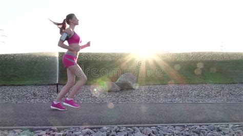 Young Attractive Athletic Woman Jogging In Park At Sunset In Slow